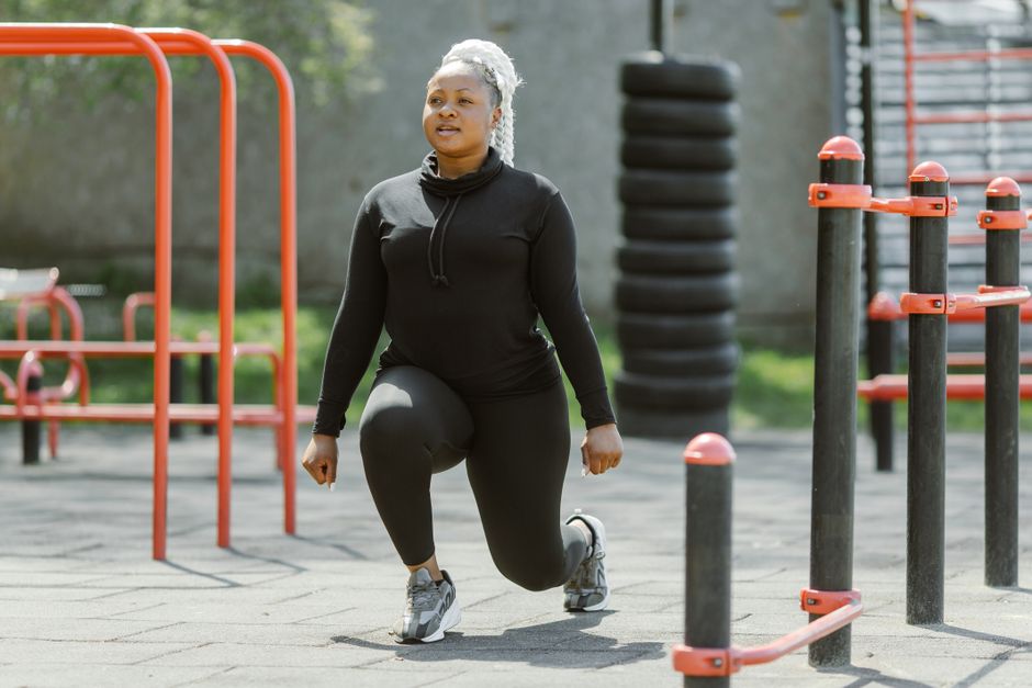 Fit žena izvodi iskorake na otvorenoj teretani